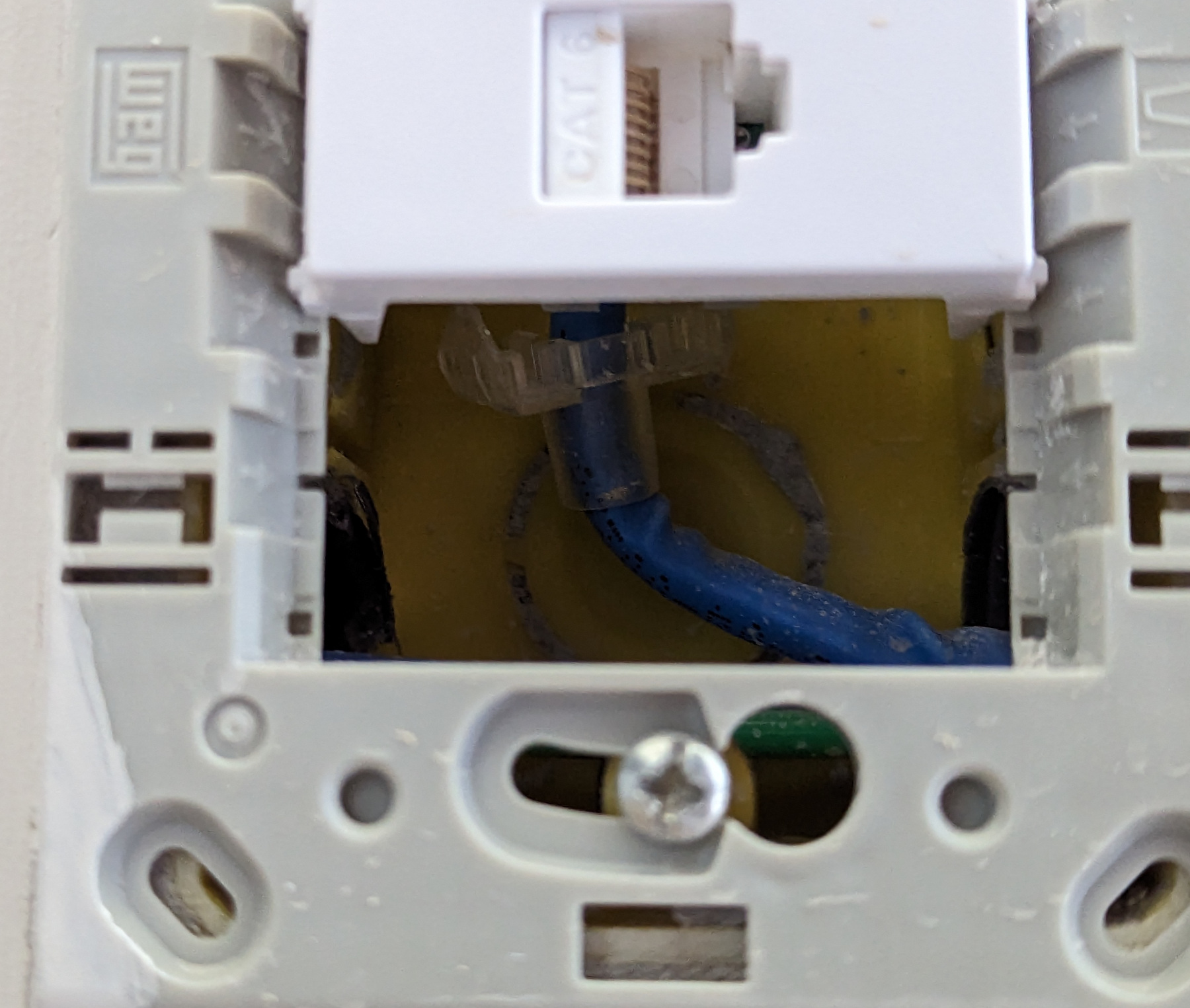 Figura 16: Numa caixa 4x2, o cabo de rede tende a ficar mal acomodado, fazendo curvas fechadas. O keystone da foto agrava o problema por crimpar os fios na traseira.