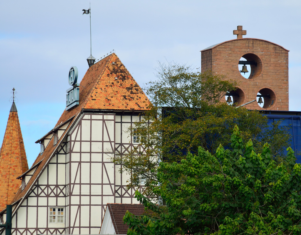 Figura 8: Dois ícones de Blumenau/SC, ambos muito próximos da Ponte de Ferro e comprimidos na mesma foto: a antiga loja Moellmann, hoje Havan, e os sinos da Catedral