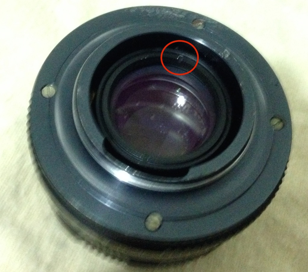 Figure 3: Lens back. Lens holder ring dent circled red.
