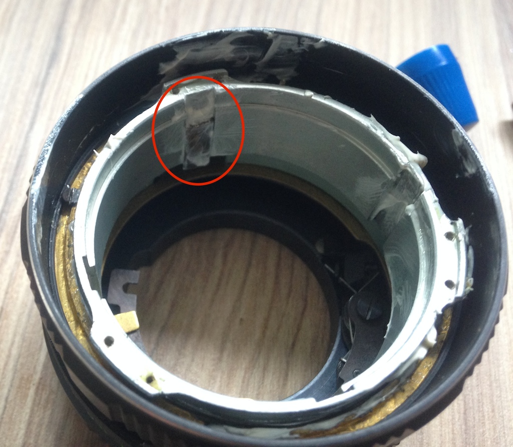 Figure 7: Outer barrel (black), focus helicoid (golden), inner barrel (silver). Circled in red: the holder that keeps the inner barrel from rotating, while allowing it to move back and forth.